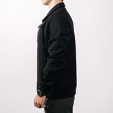 Person wearing a black jacket on a white background