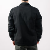 Person wearing a black jacket on a plain background