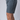 A model wearing dark grey training shorts showing a small, color-matched logo on the left leg