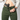 A front view of a person wearing green concealed carry joggers with an inside-the-waistband holstered handgun tucked securely into the waistband revealing a zippered fly.
