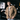Man wearing the Utility Bomber Jacket in Field Tan over a white tee and jeans in a parking garage
